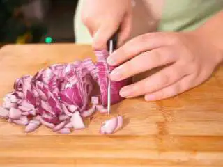 法式香橙煎鸭胸 ,将洋葱旋转90℃,从水平的方向平切洋葱,再垂直向下切成洋葱丁。