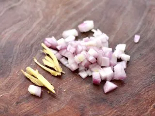 香辣孜然烤鱼,把洋葱用刀切碎，一片姜切成丝。