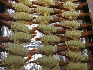 意式芝士大虾,第二步:刚出炉的大虾趁热撒上适量的现磨黑胡椒(用量根据自己的口味增减),用裱花袋套入花嘴装入土豆泥,直接把土豆泥挤在已成船型的大虾上,表面在放上马苏里拉(不要成堆太多一层铺满就好),再次撒上胡椒粉,最后用沙拉酱挤线条装饰。进入烤箱,温度200度,烤约5分钟(程度以马苏里拉奶酪完全融化为准)出炉!趁热食用!