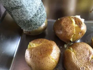 意式烤小土豆,时间到，把小土豆取出，每个反面后，稍微把每个小土豆压扁。