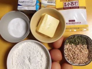 椰香坚果麦芬蛋糕,准备好食材。牛奶、椰浆、黄油、白糖、泡打粉、鸡蛋、低筋面粉、南瓜籽、花生碎、小苏打。