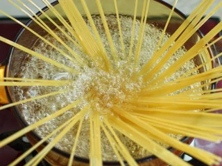 奶油蘑菇培根意面,锅中烧开水放一茶匙盐，再滴入少许橄榄油，将意面如图中呈放射状放入锅中煮12分钟左右