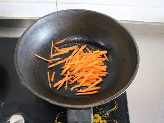 香炒意面|中式意面,起锅,锅热后倒入适量橄榄油/玉米油、不要用花生油哈(花生油、味道太香会遮盖香菇酱的味道哈),5油热下胡萝卜丝翻炒;