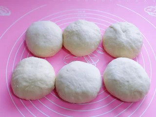 中种豆沙吐司面包,发酵好的面团分成6等份。，盖上保鲜膜松弛20分钟。