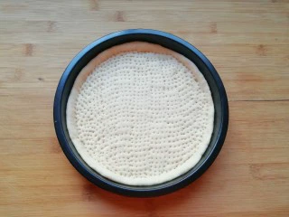 百变水果 水果披萨,用叉子扎满小孔，防止饼皮在烤制的过程中中间凸起，做好的饼底静置15-20分钟进行第二次发酵。