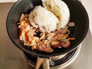 什锦咖喱焗饭,留底油。放入切好的洋葱炒出香味，炒至金黄色时，加入米饭。继续翻炒。