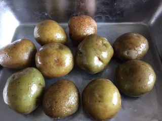 意式烤小土豆,把煮熟的小土豆入烤盘，把橄榄油摸匀每个小土豆。