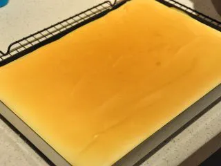 日式豆乳盒子蛋糕,烘烤结束后,取出烤盘,让烤盘从20厘米的高处摔到操作台上,震出热气。