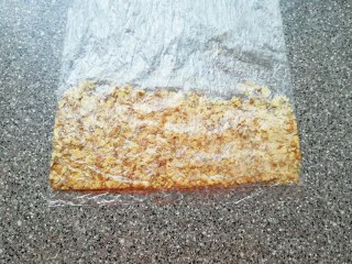 麦片芝麻核桃酥,核桃仁装进保鲜袋里面，用擀面杖压碎。