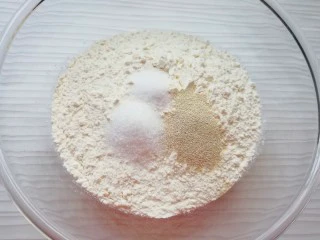 火腿彩蔬披萨,高筋面粉中加入发酵粉、盐和糖混合均匀。