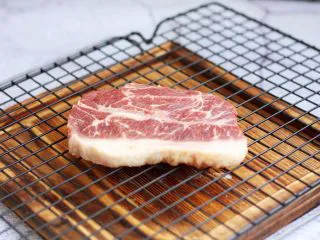 红酒黑胡椒牛排,解冻后,用厨房用纸吸干板腱牛排多余的水分。