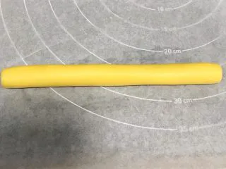 猕猴桃造型饼干,把原色面团揉成长圆柱状，长约18厘米。