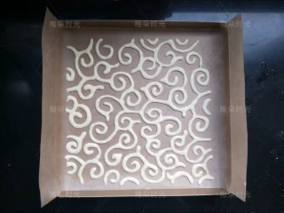 唐草彩绘蛋糕卷,放进烤箱,烤2分钟。烤定型。然后把底下的图纸抽出来。