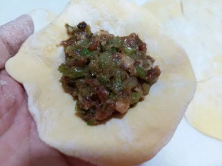 南瓜芹菜肉包子,将馅料放在包子皮的中央,开始包包子