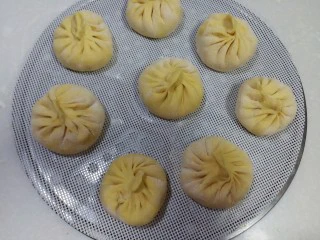 南瓜芹菜肉包子,将醒好的包子放在铺了屉布的蒸帘上,放入蒸锅里开大火蒸15分钟后在锅里焖3~5分钟取出。