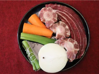 法式牛肉暖锅,牛腱子外面的筋膜去掉,牛尾发硬发黄的油脂去掉。胡萝卜削皮,将丁香插在洋葱上。