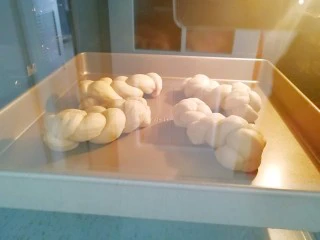 果酱辫子面包,另一烤盘加入半烤盘水放入烤箱最下层，放面包的烤盘放入烤箱的中下层，选择烤箱的“发酵”功能，35度二次发酵40分钟。