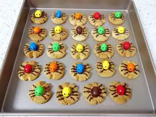 万圣节蜘蛛饼干,所有做好的蜘蛛饼干码在烤盘里，让巧克力凝固。