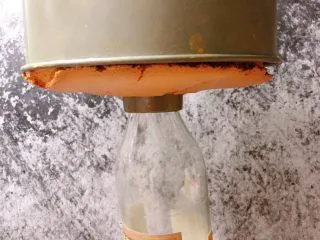 奶油奶酪戚风,烤好在桌子上震几下,完事找个瓶子吧模具倒扣,等凉了就可以脱模了