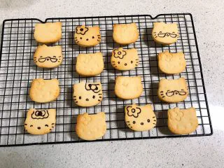 可爱KT小饼干,烤好的饼干晾凉，用融化的黑巧力或者食用色素笔装饰一下。