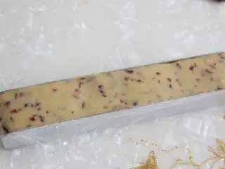 香酥美味蔓越莓饼干,和好的面团外面包层保鲜膜放入饼干模具中整形。将做好的饼干面团放入冰箱冷冻一小时。