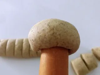 黑豆渣窝窝头,面团放左手掌心,用手不好弄就用擀面杖摁出小窝,慢慢摁一圈。