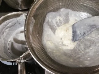 胡萝卜浓汤意面,用铲子在过滤这里搅拌，让汁尽量的都流下来