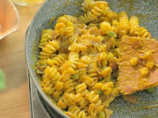 芝士南瓜焗意面,依次倒入南瓜泥、玉米青豆、意面,翻炒均匀。因为比较干,所以要加入一点牛奶,才能把食材都炒匀。你也可以用清水来代替牛奶。