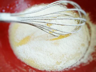 火龙果盒子蛋糕,蛋黄中加入玉米油细砂糖，牛奶搅拌均匀到乳化状态，筛入低筋面粉