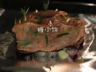 【迷迭香烤羊腿】中西混搭版,将洋葱和剩余的蒜片铺在锡纸上，再把羊腿架在洋葱片上