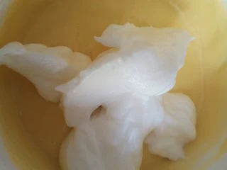 平底锅舒芙蕾,把三分之一的蛋白倒入蛋黄糊中,翻拌匀