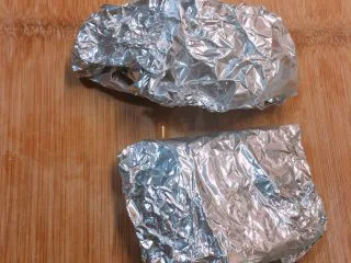 烤肉汁鸡胸肉,腌制15分钟后准备锡纸,放入蒜片,将其包裹起来,包裹的过程中,烤箱或微波炉可以预热起来。