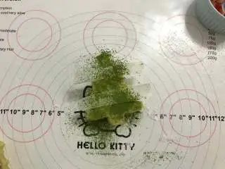 迷你圣诞树蛋糕,取两条小纸条放到蛋糕上，撒上适量抹茶粉装饰即可。 