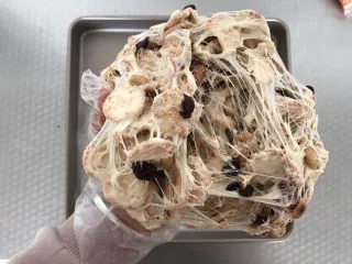 网红草莓雪花酥,将雪花酥料拿起来，用手反复柔和，拉丝，这样让棉花糖均匀的裹在坚果和饼干上，雪花酥就会更有嚼劲，而且也不会硬