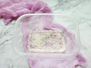 火龙果牛奶小方,取一个模具或者玻璃保鲜盒底部撒适量椰蓉。