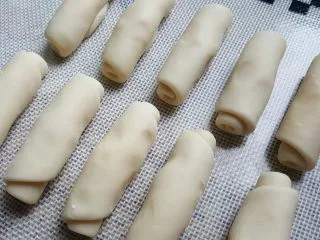 中式点心~玫瑰酥,取一份面团擀成长,从上而下卷起。