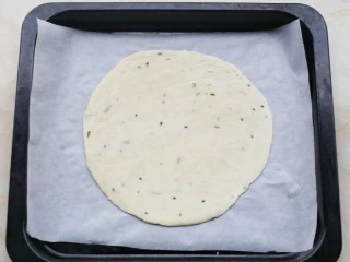 酥到掉渣的爆浆奶香芝士红薯饼,手抓饼平铺在铺上油纸的烤盘上。