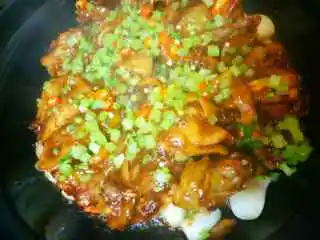 生焗啫啫湛江鸡,加入切好的香菜 葱花撒上面加盖大火烧20 秒加酒(白酒 红酒 白兰地)那一种都可以 撒少许从盖子边淋r即可