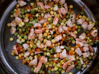 什锦虾仁焗饭,加入玉米粒，青豆和精盐翻炒2分钟