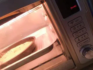 小白也会的奥尔良烤鸡腿披萨 「8寸薄脆版」,放进烤盘里，然后烤箱开启发酵功能，放进去，醒发15-20分钟。或者放到30-40度温度的地方，醒发面饼。没有的话，就室温包上保鲜膜就好。