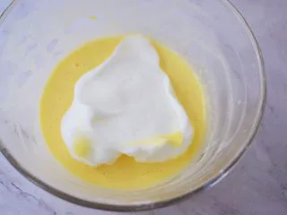 酸奶蛋糕(黄油版),将三分之一的蛋白霜加入蛋黄中,翻拌均匀