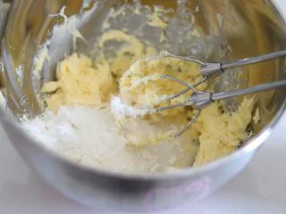 醇香酥脆的曲奇饼干(曲奇枪版),冬日温暖小零食,4、用打蛋器把黄油搅拌匀,无需打发,倒入细砂糖和糖粉,先压拌一下让糖粉融入到黄油中,之后开启电动打蛋器打发到黄油发白,而且比较蓬松