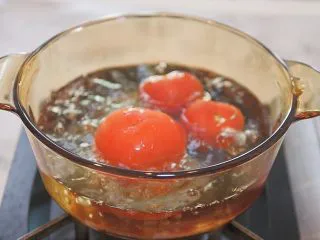 蕃茄意大利直筒面,番茄顶部切划十字，放入沸水中烫一分钟