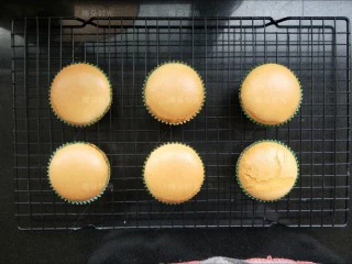 奶油纸杯蛋糕,烤好的蛋糕取出带着烤盘端起来轻震几下，然后放在晾网上凉一下。