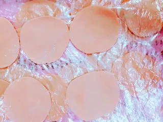 马卡龙色 高颜值汤饺系列@@ 猪肉大葱馅●麦穗饺,再用擀面杖搞成圆形，手法是左手一边转面，右手一边擀，边缘一定不要厚了。厚度呢，不要太薄，也不要太厚。自己感觉一下，我说不太清楚，这个厚度。看下图就感觉一下。为了不粘连，我从做千层蛋糕那里找到灵感，用保鲜膜一层一层的铺开隔开。因为我觉得加干面，会让面皮边缘变干，而且不好捏在一起。我自己包，包得不快，怕它们硬了不好塑型，就这样做。还干净。