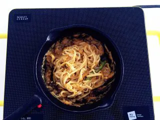 南瓜酱汁牛肉面,加入步骤3中的手工面，关火，面条热热的，平底锅里的南瓜糊也是热乎乎的，一起搅拌均匀即可。