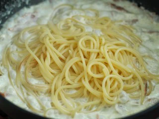 奶油蘑菇培根意面,将煮好的意面捞出放入锅中拌匀