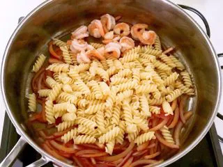 什锦虾仁焗意面,加入煮熟的螺丝面和虾仁，加入黑胡椒粉，精盐翻炒均匀