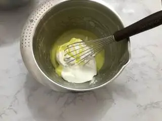 迷你圣诞树蛋糕,取三分之一的蛋白霜加入蛋黄糊中，用切拌手法搅拌均匀。