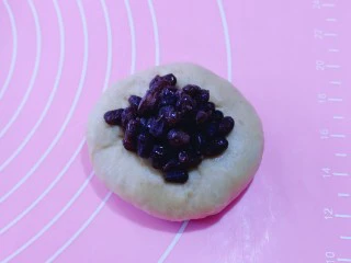 红豆日式咖啡面包卷,取一块面团,用擀面饼,加入红豆,如包包子的手法包起来!依次包完!